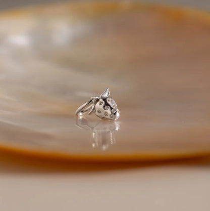 Silver ring with a unique design on a reflective surface