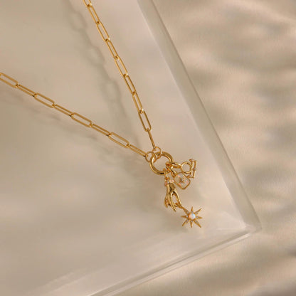 Gold necklace with a star-shaped pendant on a soft beige background