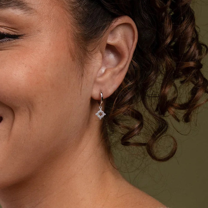 Woman with a warm smile and curly hair against a neutral background