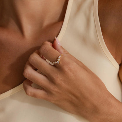 Close-up of a hand wearing a diamond ring on a neutral background