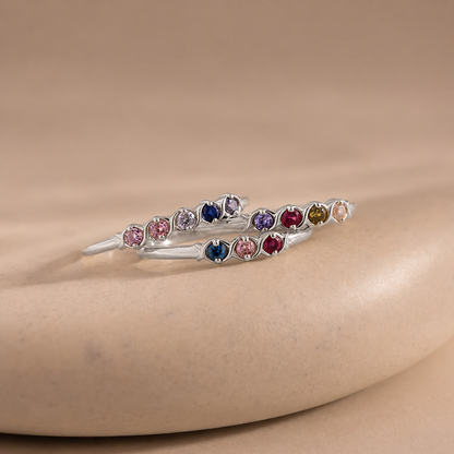 Silver bracelet with multicolored gemstones on a beige surface