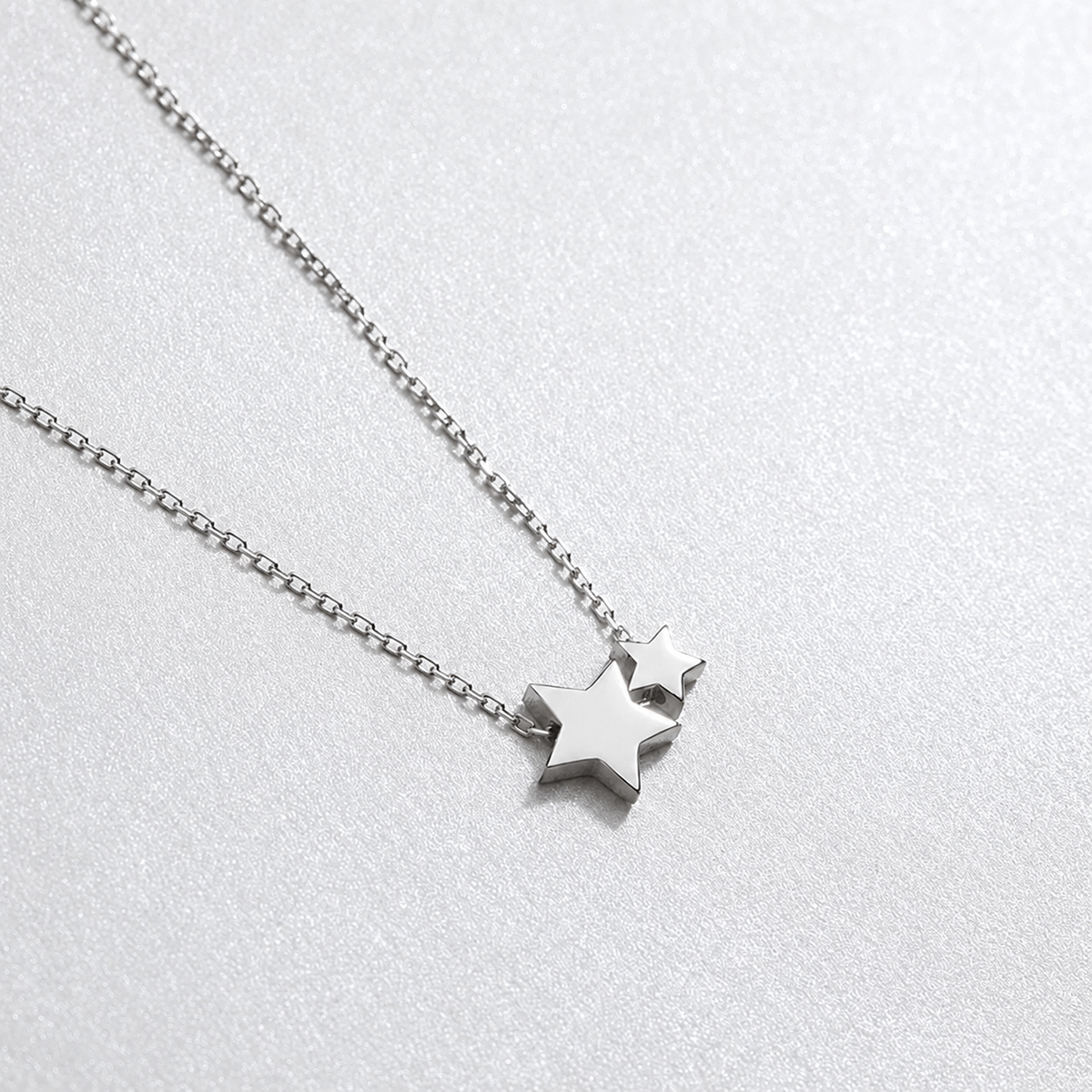 Silver star necklace on a light gray background