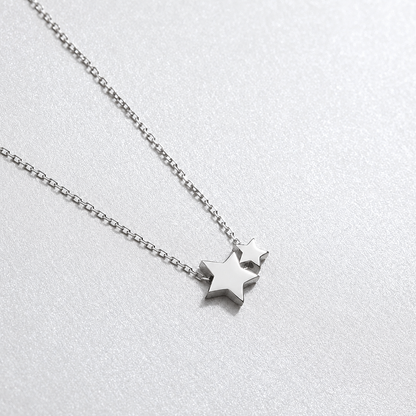 Silver star necklace on a light gray background