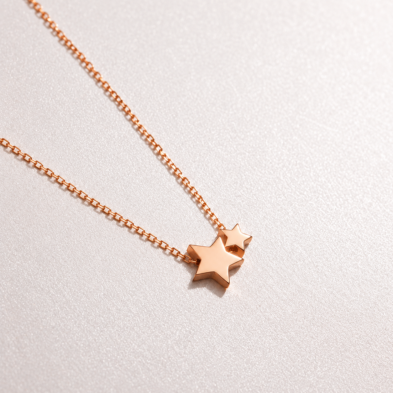 Rose gold star-shaped pendant necklace on a light gray background