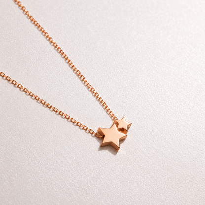 Rose gold star-shaped pendant necklace on a light gray background
