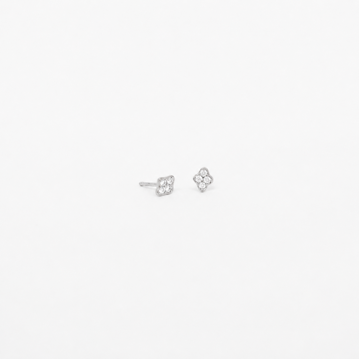A pair of small silver stud earrings with a floral or clover-like openwork design, shown on a plain white background.