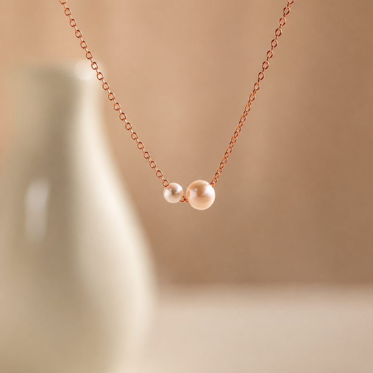 Necklace with two pearls on a beige background