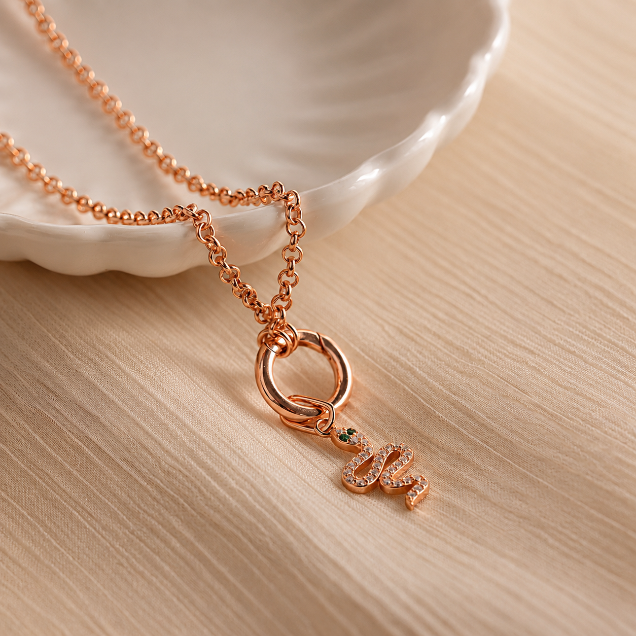 Rose gold necklace with a pendant on a beige surface