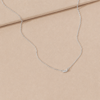 Silver necklace on a beige fabric background