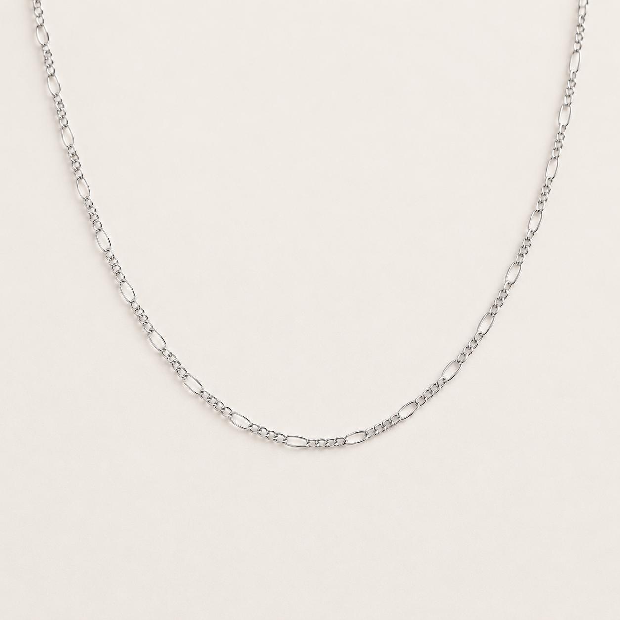 Silver chain necklace on a light gray background