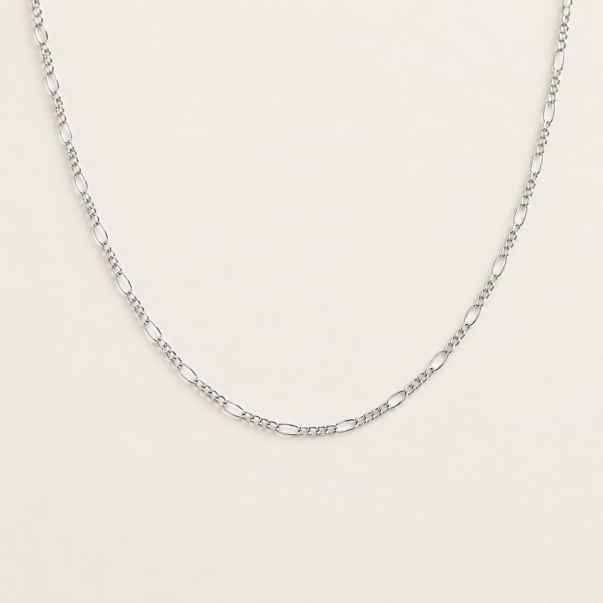Silver chain necklace on a light gray background