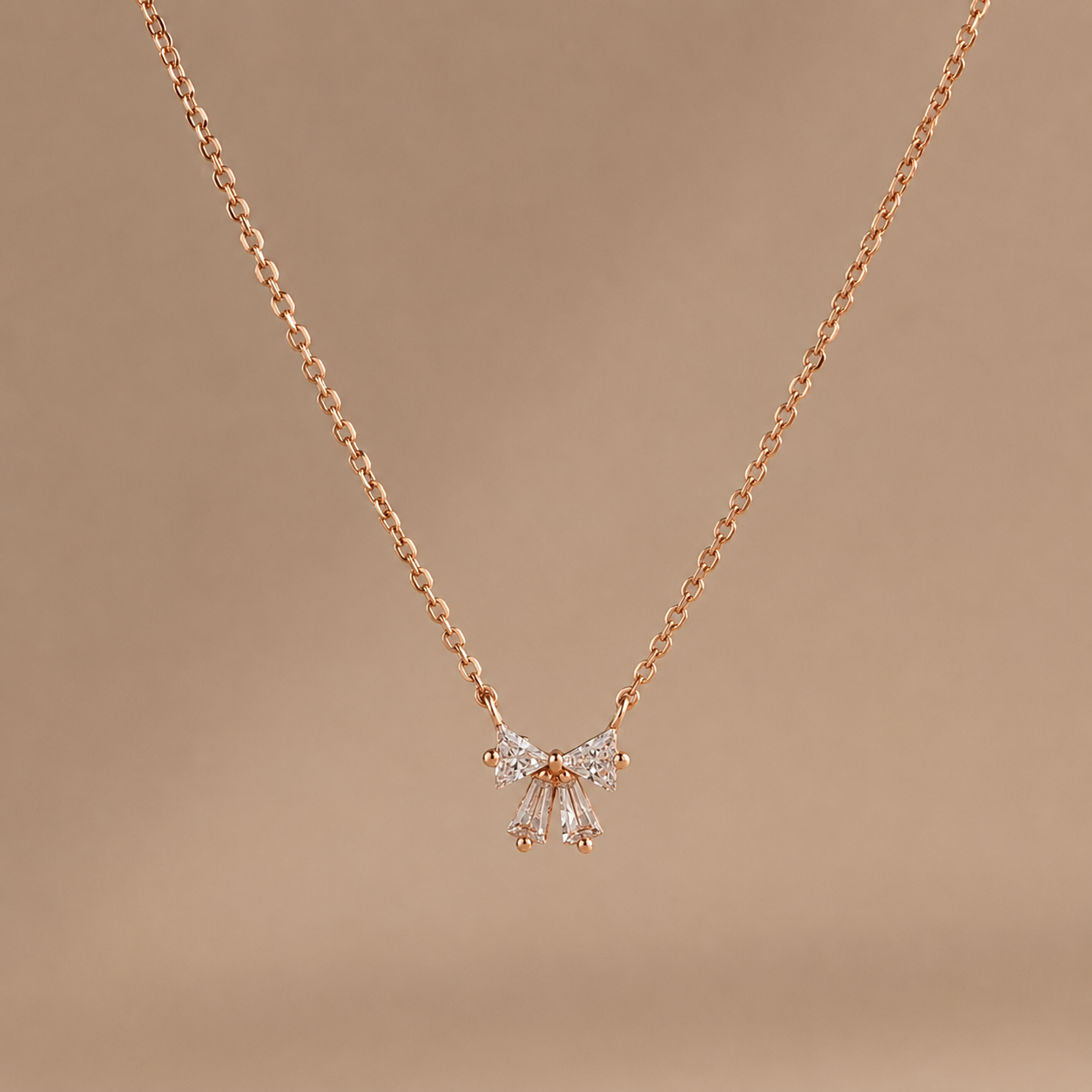 Rose gold necklace with a butterfly pendant on a brown background