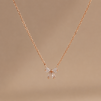 Rose gold necklace with a butterfly pendant on a brown background