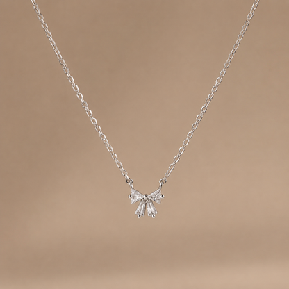 Silver necklace with a delicate pendant on a brown background