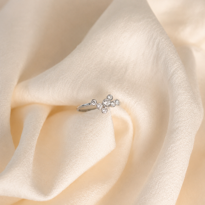 Silver ring with diamonds on a soft beige fabric background