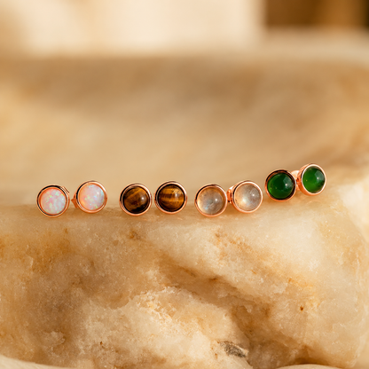 Set of gemstone stud earrings on a marble surface