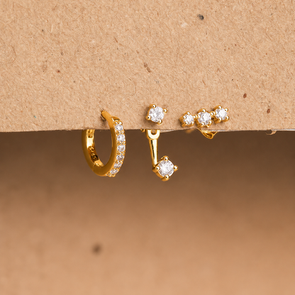 Gold hoop earrings with embedded diamonds on a brown background