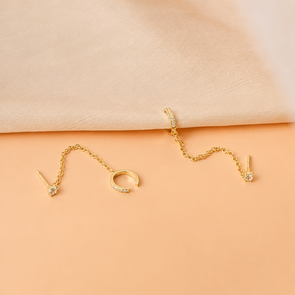Gold jewelry set on a peach-colored fabric background