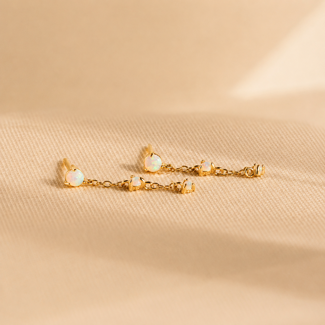 Gold bracelet with small round stones on a beige fabric background