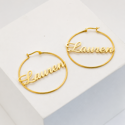 Gold hoop earrings with 'Lauren' engraving on a white background