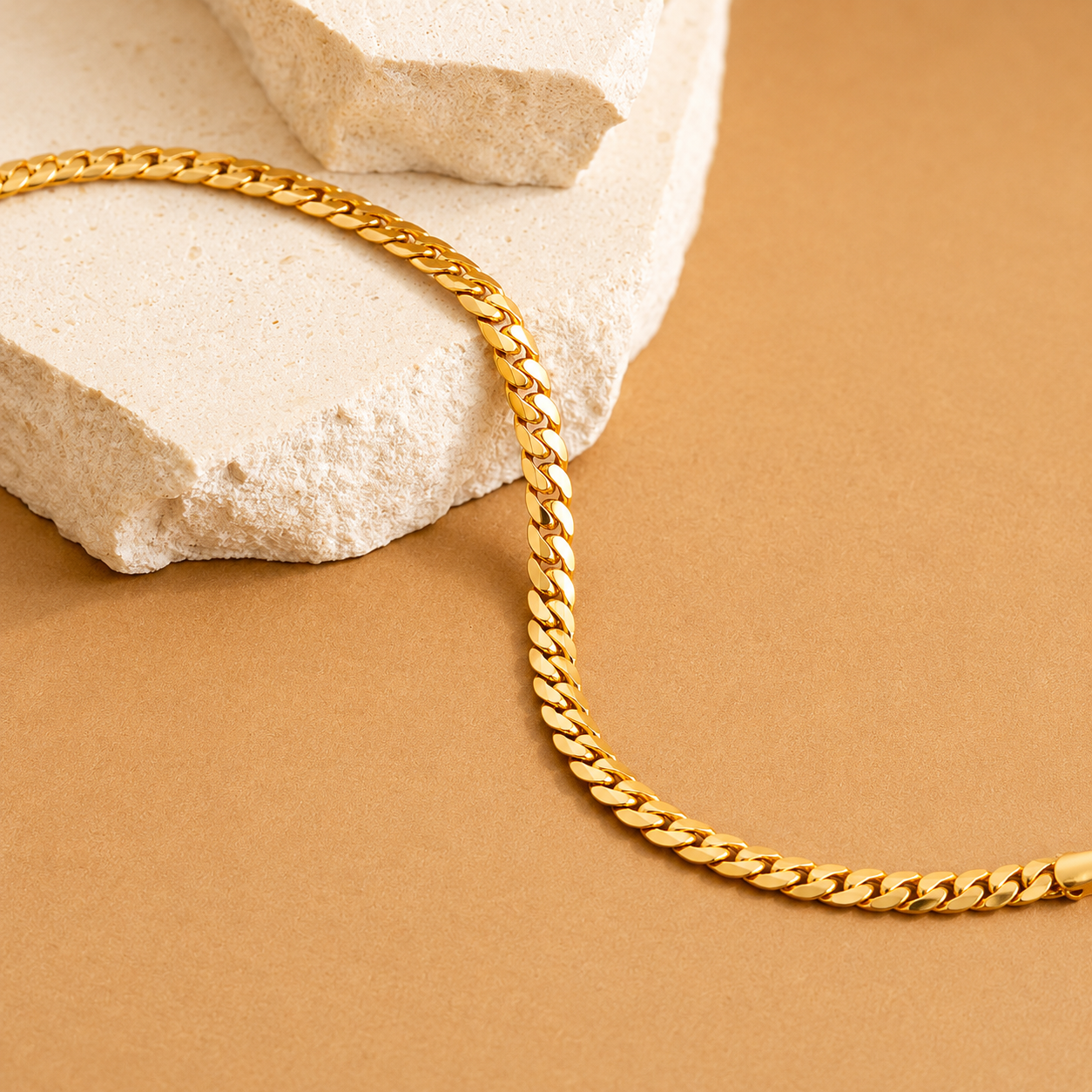 Gold chain on a textured beige surface