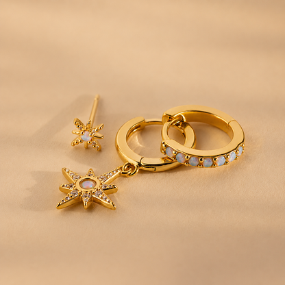 Gold hoop earrings with star-shaped charms on a beige background