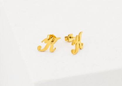Gold letter 'H' earrings on a white background