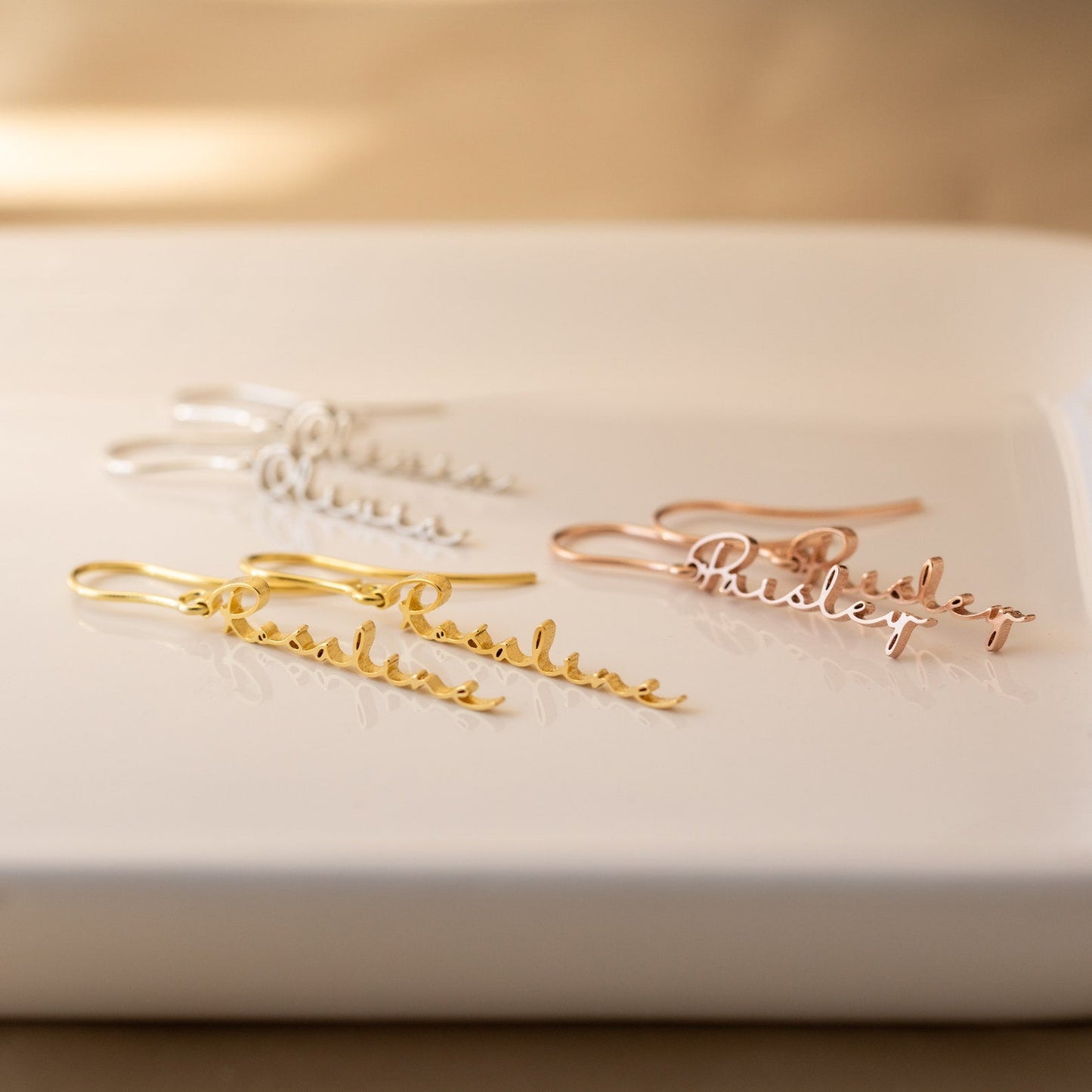 Personalized name earrings in sterling silver, 18K gold, or rose gold, featuring custom name or text in a elegant font