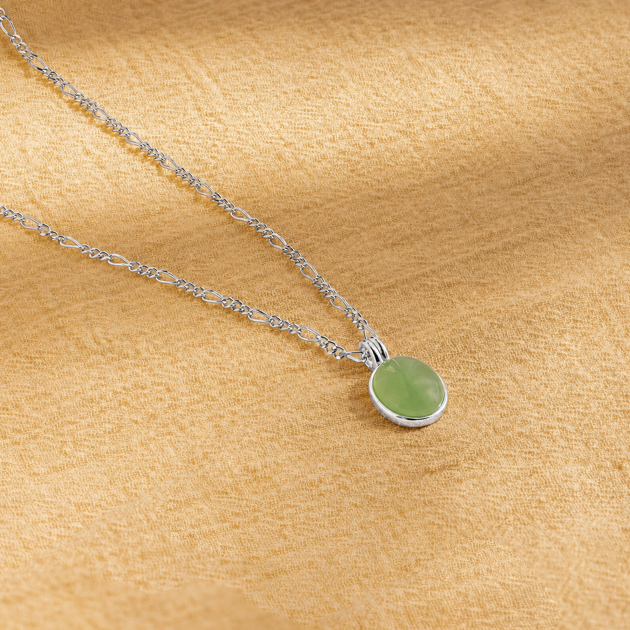 Necklace with a green pendant on a beige fabric background