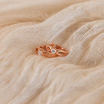 Rose gold ring with diamonds on a beige fabric background