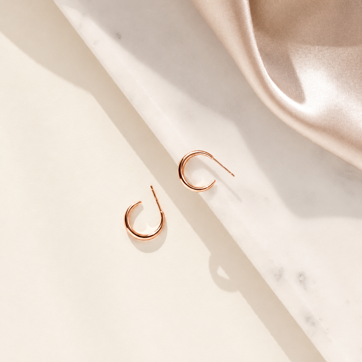 Rose gold earrings on a marble surface