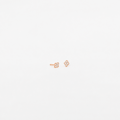 A pair of small rose gold stud earrings with a four-petal flower design set with tiny clear stones, shown on a plain white background.