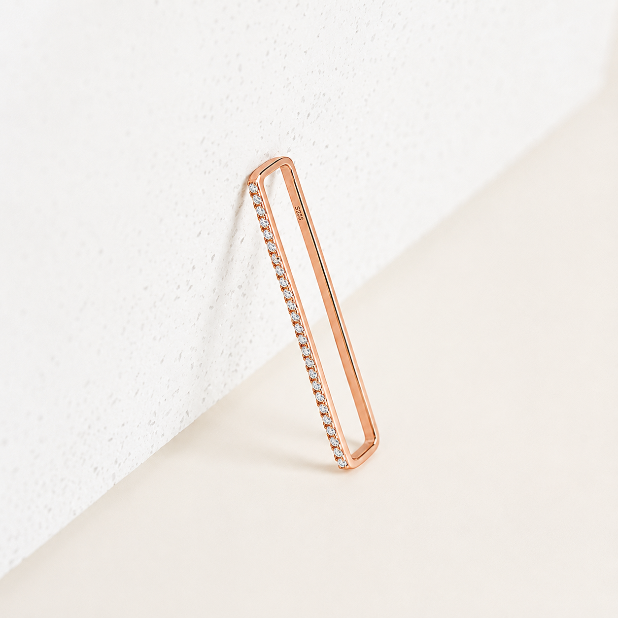 Rose gold ring with embedded stones on a light background