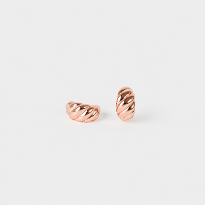 A pair of twisted rope-style hoop earrings in polished rose gold, displayed on a clean, light gray background.