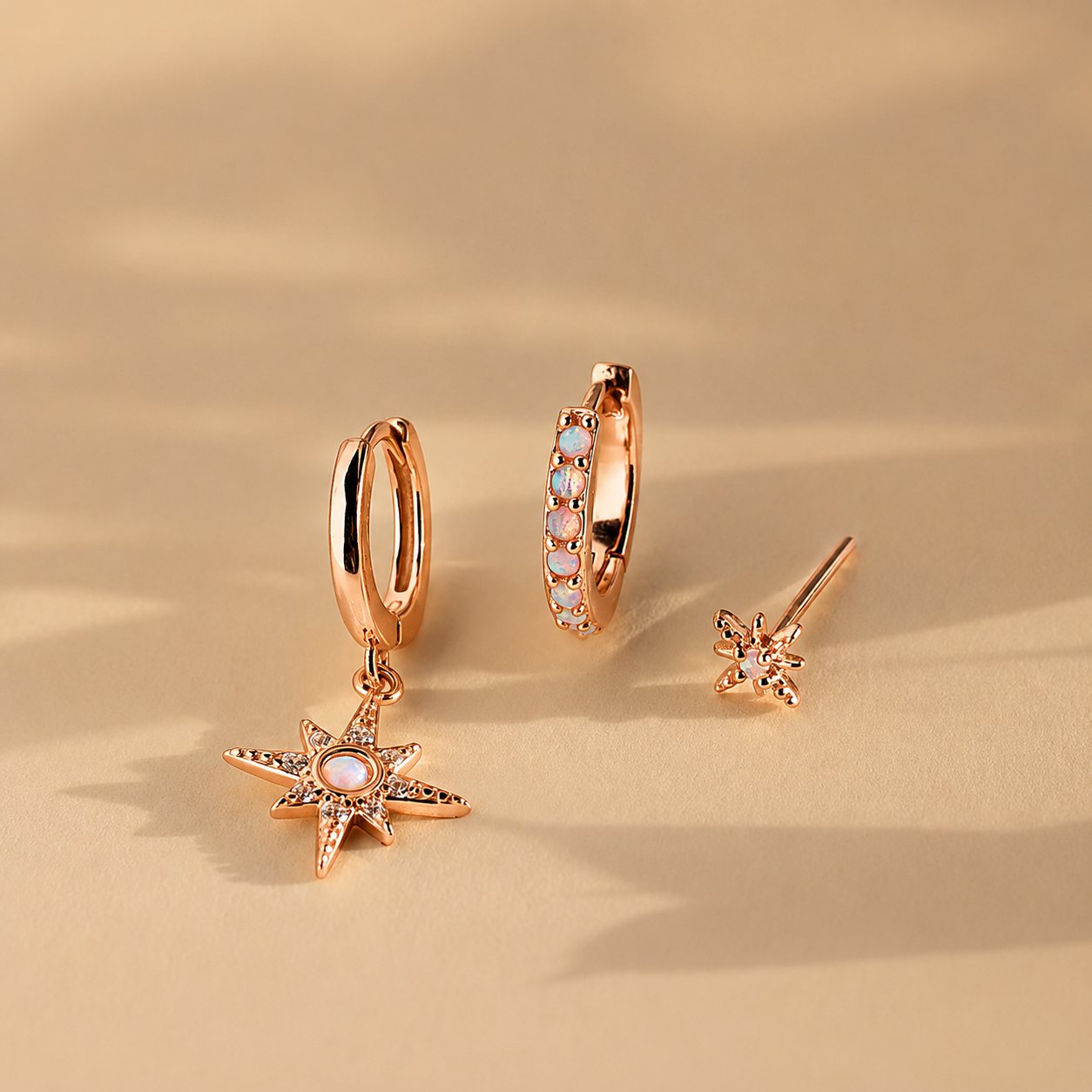 Set of rose gold earrings on a beige background