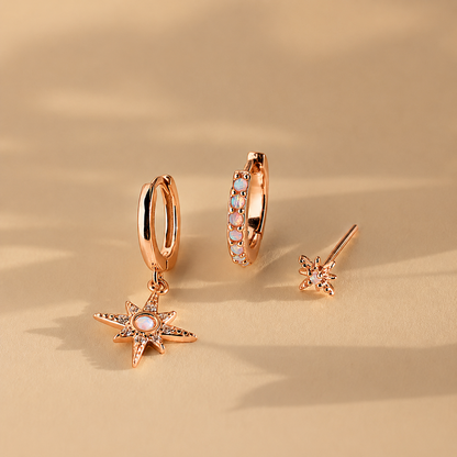 Set of rose gold earrings on a beige background