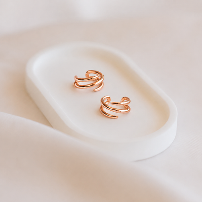 Rose gold earrings on a soft white background