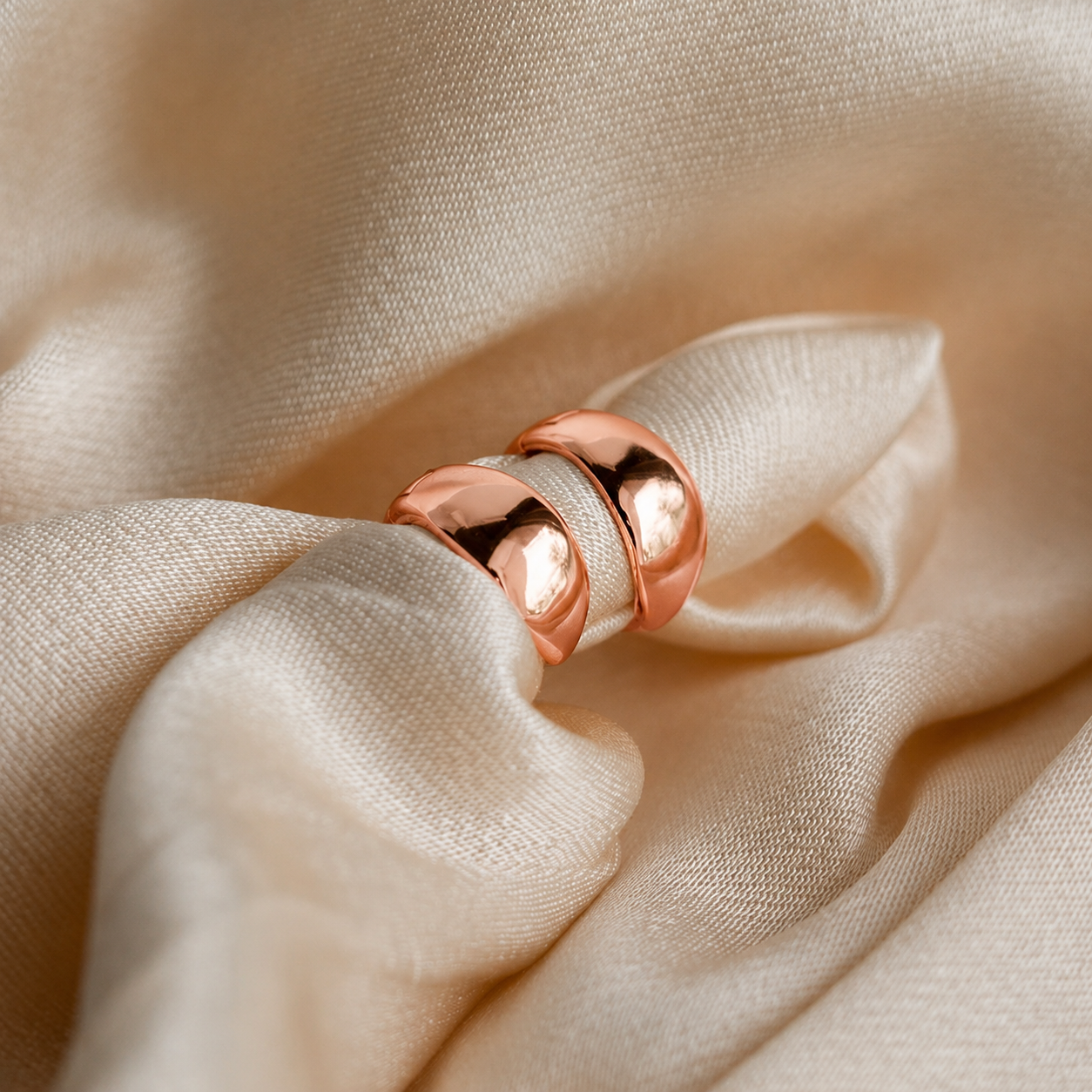 Rose gold ring on beige fabric