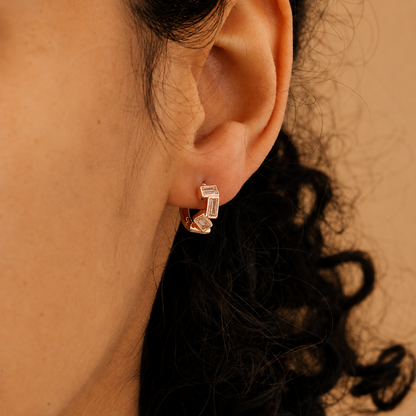 Close-up of an ear wearing a diamond earring with a blurred background