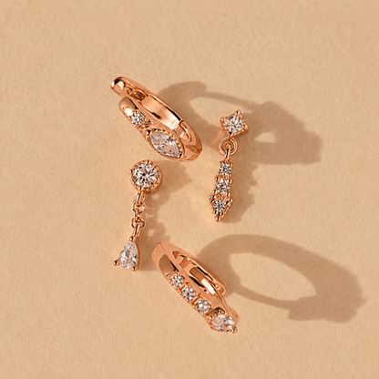 Set of rose gold earrings on a beige background