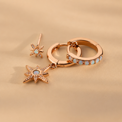 Rose gold earrings with star designs on a beige background