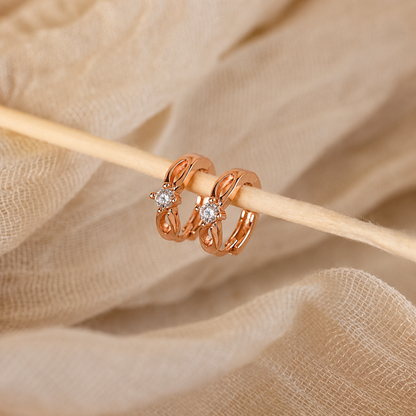 Rose gold rings with diamonds on a beige fabric background