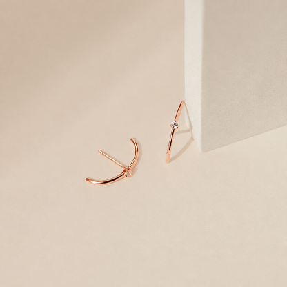 Rose gold earrings on a beige background