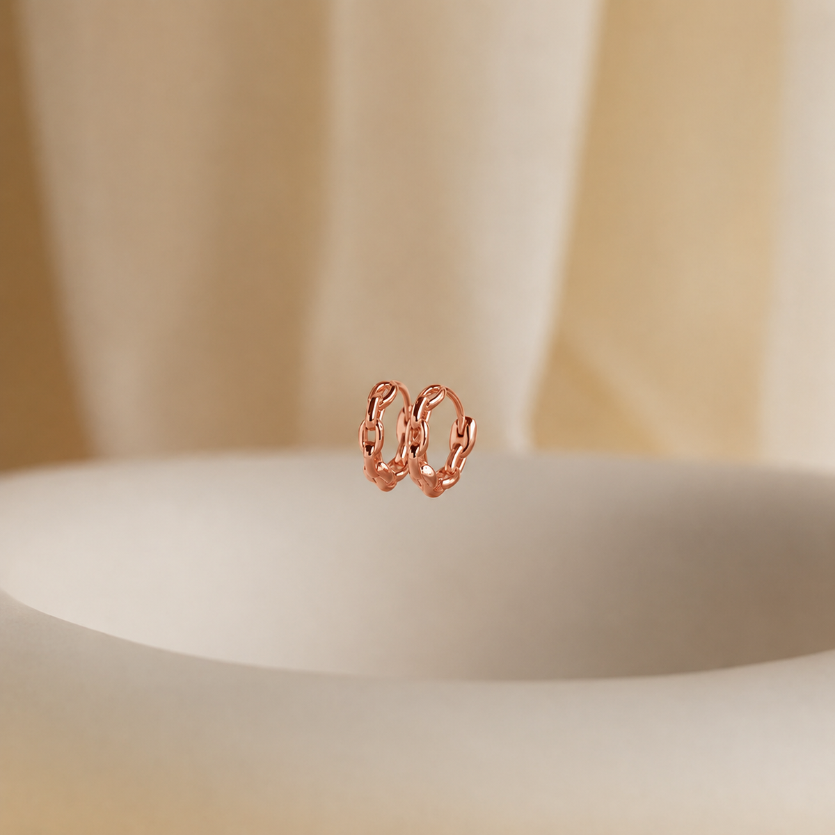 Rose gold hoop earrings on a neutral background