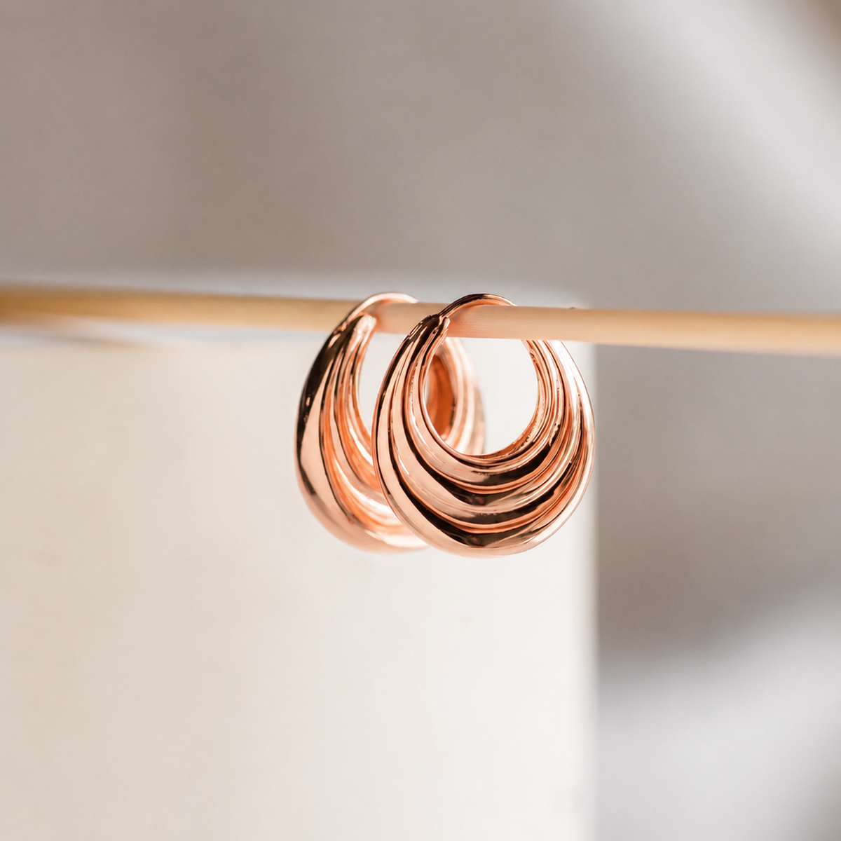 Rose gold earring on a blurred background