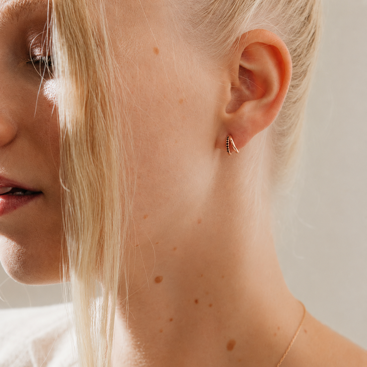 Close-up of a woman wearing a gold earring with a blurred background