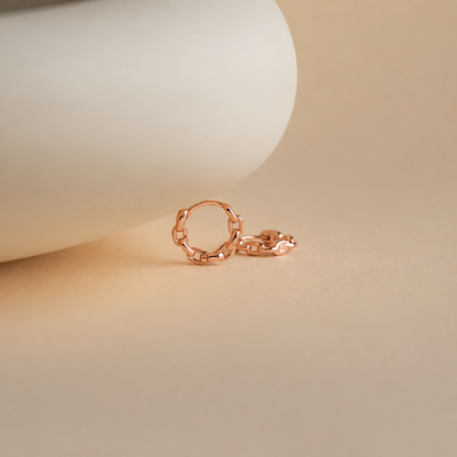 Rose gold chain ring on a beige background