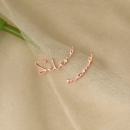 Rose gold 'Selena' earrings on a beige fabric background