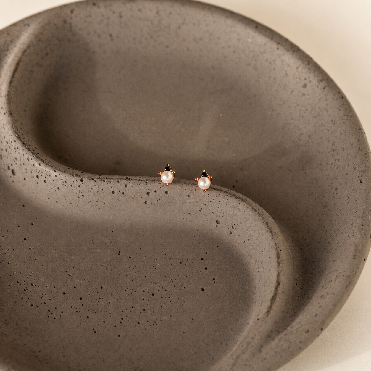 Pair of earrings on a textured gray surface