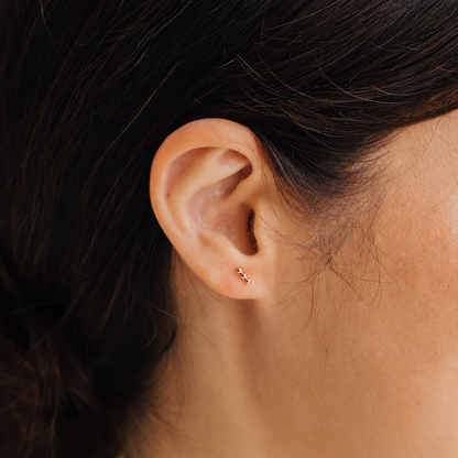 Close-up of an ear with a small gold earring